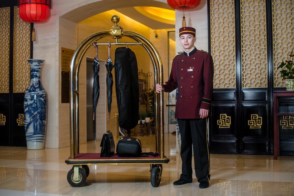 Beijing Palace Soluxe Hotel Astana Εξωτερικό φωτογραφία A bellboy with a luggage cart